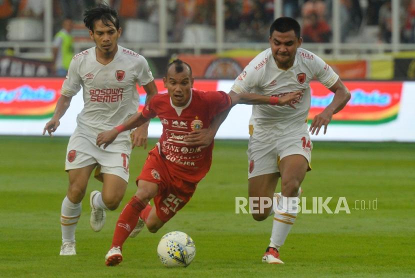 Pemain Persija Jakarta Riko Simanjuntak  berebut bola dengan pemain PSM Makassar dalam laga lanjutan Liga 1 di Stadion Gelora Bung Karno, Senayan, Jakarta, Rabu (28/8).