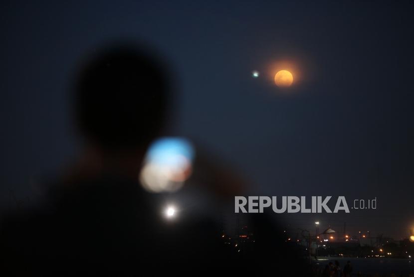 Warga memfoto penampakan gerhana bulan total super blue blood moon di Kawasan Acol, Jakarta, Rabu (31/1).