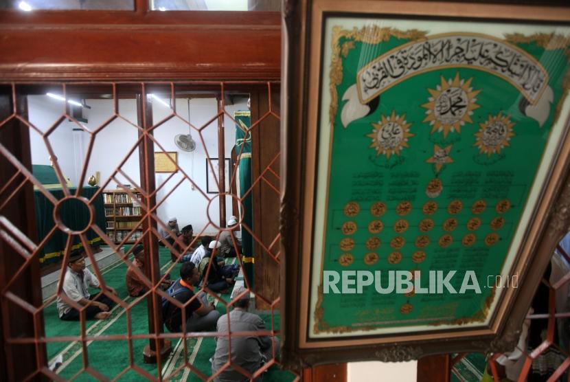 Warga berdoa saat berziarah di Masjid Luar Batang, Jakarta, Senin (12/11).