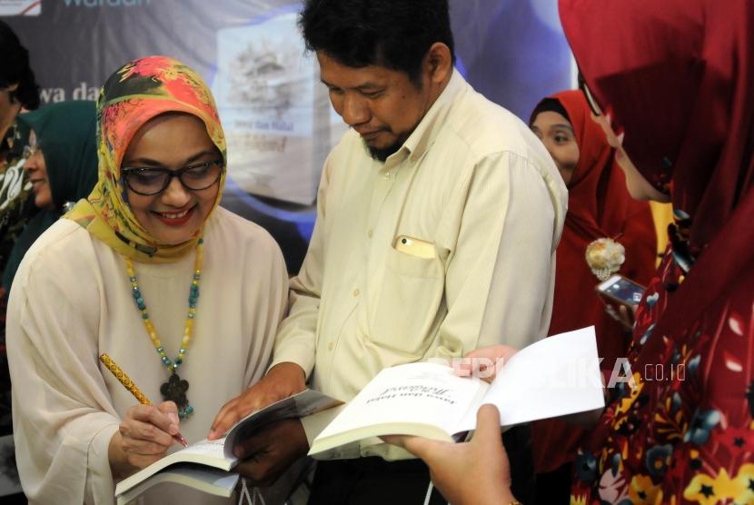 Penulis Buku Jawa dan Halal di Thailand Marissa Haque Fawzi (kiri) memberikan tanda tangan pada buku karangannya usai launching dan bedah buku Jawa dan Halal di Thailand di Gedung Pusat Dakwah Muhammadiyah, Jakarta, Senin (26/2).
