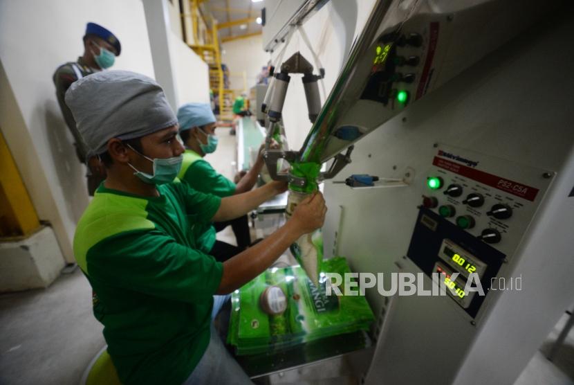 Pegawai  mengemas beras di mesin pengolah beras usai diresmikan di Pergudangan Pasar Induk Beras Cipinang, Jakarta, Kamis (20/12).