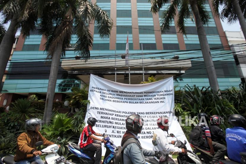 Pengendara motor melintas didepan spanduk pemberitahuan penutupan Hotel Alexis terpampang di pinggir jalan depan Alexis. Jakarta, Rabu (28/3).