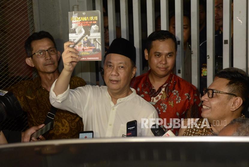 Mantan Kepala Badan Penyehatan Perbankan Nasional (BPPN) Syafruddin Arsyad Temenggung memperlihatkan buku karanganya sebelum meninggalkan Rutan KPK, Jakarta, Selasa (9/7).