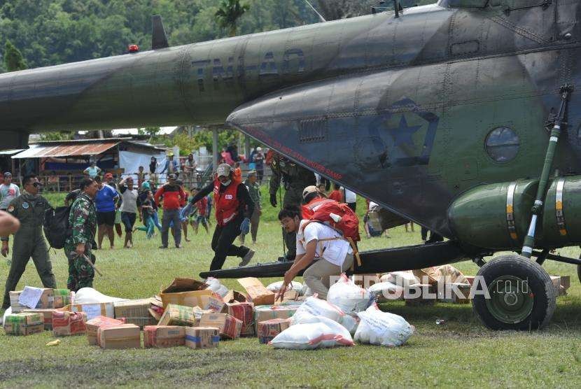 Bantuan Untuk Daerah Terisolir : Petugas TNI AD bersama PMI menurunkan bantuan untuk korban gempa yang diangkut menggunakan helikopter TNI AD MI 17 di Desa Bolapapu, Kolawi, Kabupaten Sigi, Sulawesi Tengah, Senin (8/10).