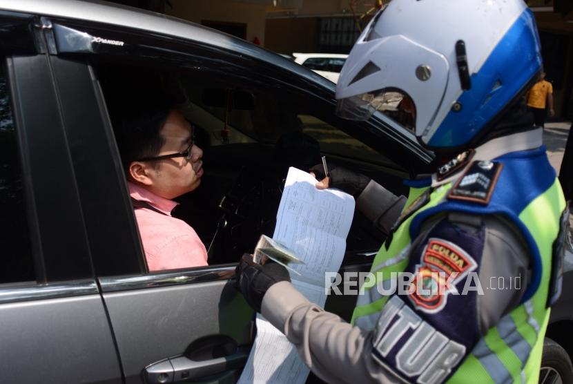 Petugas kepolisian mengamankan kendaraan roda empat di kawasan perluasan ganjil genap Jalan Majapahit, Jakarta, Senin (9/9/2019).