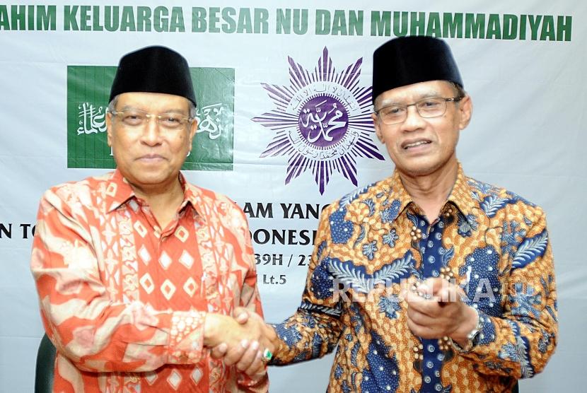 Ketua Umum PBNU Said Aqil Siroj dan Ketua Umum PP Muhammadiyah Haedar Nashir (dari kiri) bersalaman usai melakukan silahturahim di Gedung PBNU, Jakarta, Jumat (23/2).