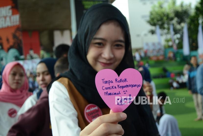 Pengunjung memperlihatkan tulisan dukungan tampa rokok saat pameran seni instalasi karya seniman nasional Ika Vantiani dalam rangka memperingati Hari Tanpa Tembakau Sedunia yang digelar Pemerintah Kota Bandung, di Taman Film, Kota Bandung, Ahad (27/5).