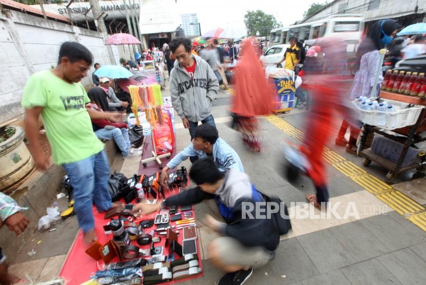 Pedagang melayani pembeli di trotoar kawasan Tanah Abang, Jakarta, Kamis (14/12).