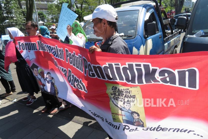 Puluhan orang tua siswa yang tergabung dalam Forum Masyarakat Peduli Pendidikan Se-Jawa Barat melakukan unjuk rasa menolak sistem Penerimaan Peserta Didik Baru (PPDB) di depan Gedung Sate, Senin (9/7).