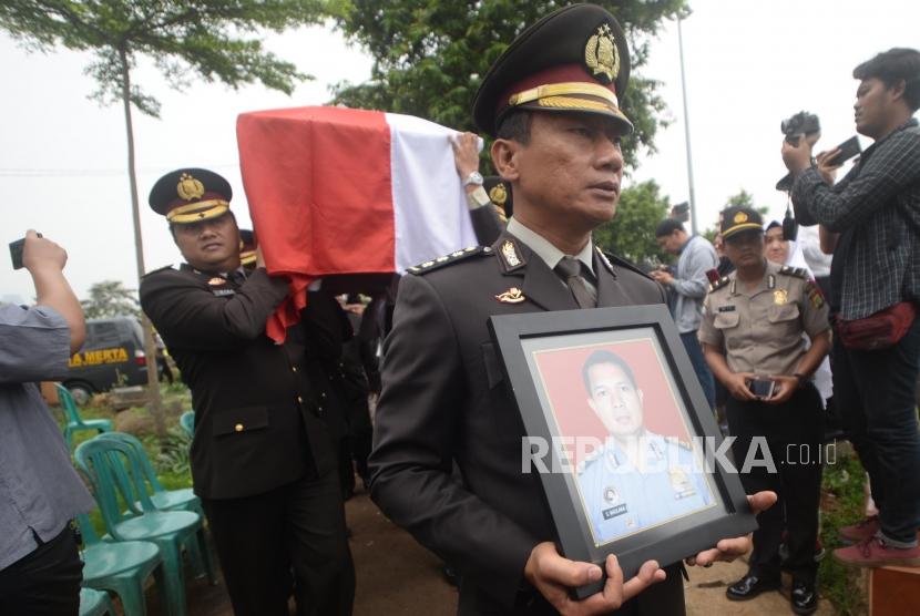 Anggota Kepolisian membawa  foto  dan  Jenazah korban jatuhnya pesawat Lion Air PK-LQP  AKBP Sekar Maulana saat pemakaman di TPU Karet Bivak, Jakarta, Kamis (8/11).