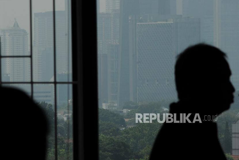 Teknologi Hujan Buatan Atasi Polusi Jakarta. Masyarkat beraktifitas dengan latar belakang gedung bertingkat terlihat samar karena polusi udara di Jakarta, Selasa (3/7).