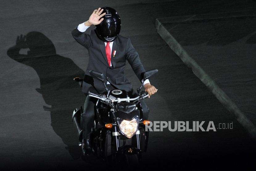 Presiden Joko Widodo menaiki motor saat pembukaan Asian Games 2018 di Stadion GBK, Senayan, Jakarta, Sabtu (18/8).