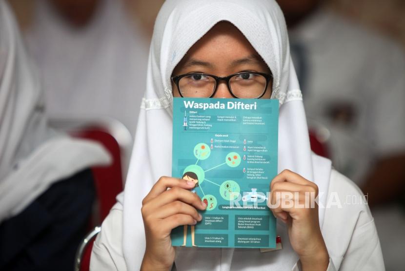 A student show brochure of Diphtheria awareness after getting immunization at SMAN 33 Jakarta, West Jakarta, on December 11, 2017.