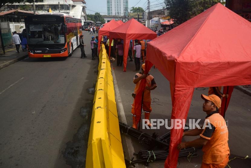 Petugas PPSU mendirikan tenda yang akan digunakan pedagang kaki lima (PKL) untuk berjualan ketika dilakukanya penutupan Jalan Jatibaru di Kawasan Tanah Abang, Jakarta, Jumat (22/12).