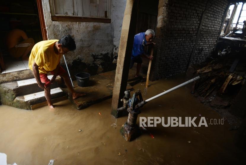 Warga saat membersihkan sisa banjir yang menggenangi kawasan Kampung Melayu, Jakarta, Senin (12/11).