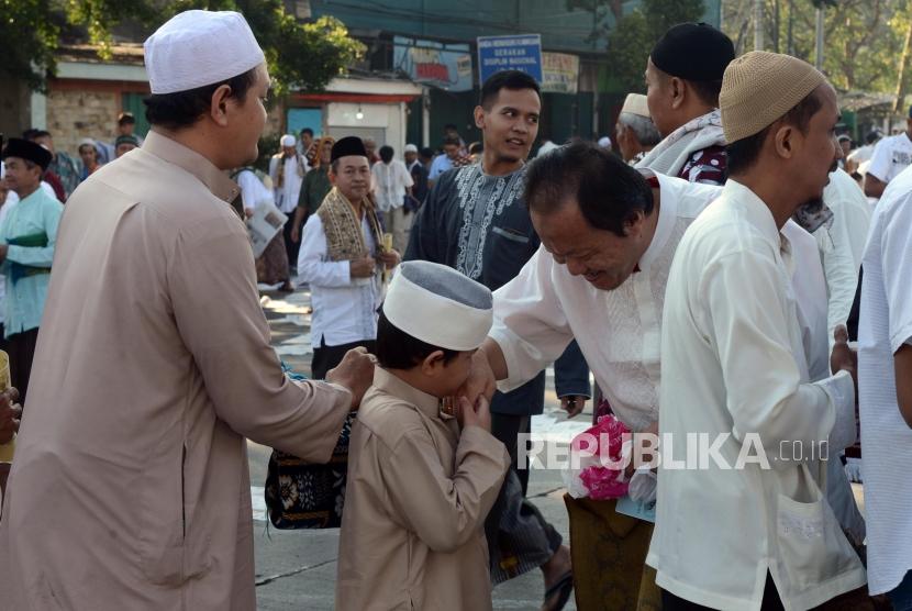 Sejumlah umat muslim bersalaman usai melaksanakan ibadah Shalat Idul Fitri di Jatinegara, Jakarta, Rabu (5/6). Naskah Khutbah Jumat: Keutamaan Memberi Maaf