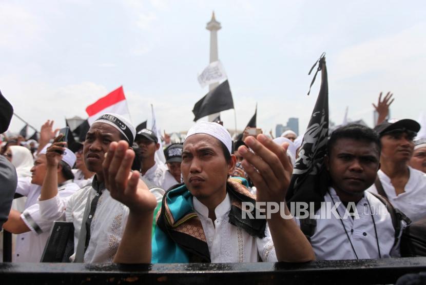 Peserta berdoa saat mengikuti reuni aksi 212 di Lapangan Monumen Nasional, Jakarta, Ahad, (2/12).