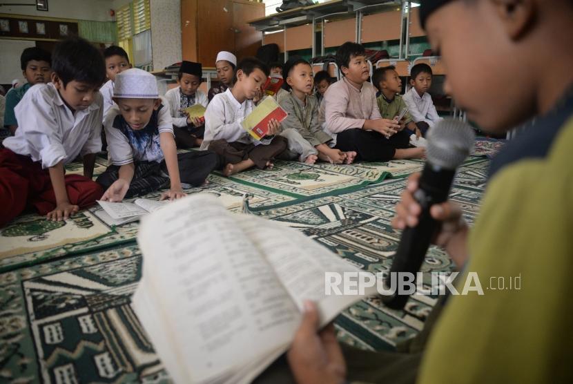 Sejumlah siswa-siswi membaca Juz Amma saat mengikuti kegiatan pesantren kilat Ramadhan di SDN Menteng Atas 02 , Jakarta, Jumat (10/5).