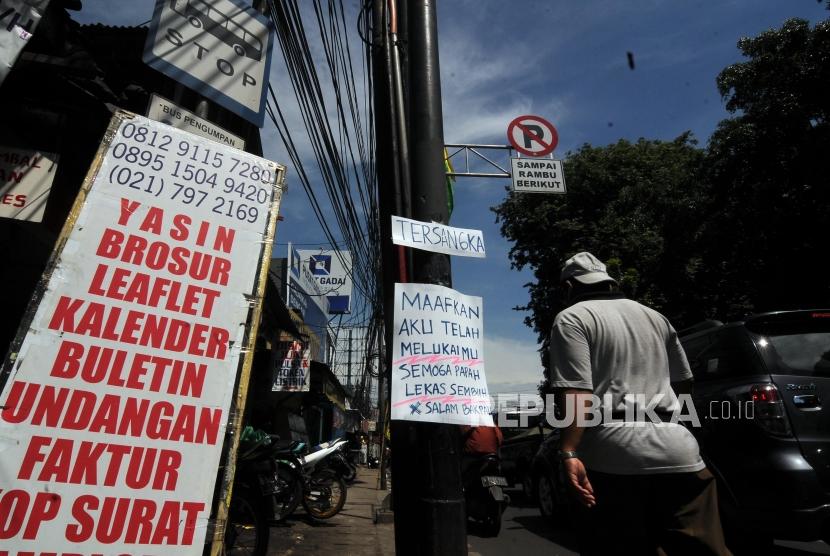 Sebuah tiang listrik dipasangkan poster bertuliskan kalimat sindiran untuk Ketua DPR Setya Novanto di Jalan Raya Pasar Minggu, Jakarta Selatan, Senin (20/11).