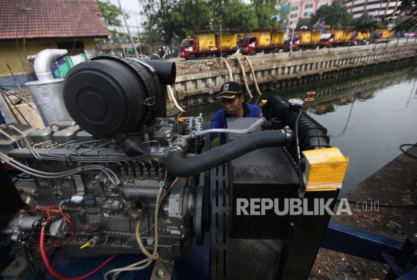 Petugas Sumber Daya Air Aliran Timur dan Barat mengoperasikan mesin pompa penyedot air di kawasan Kali Item, Kemayoran, Jakarta, Kamis (2/8).