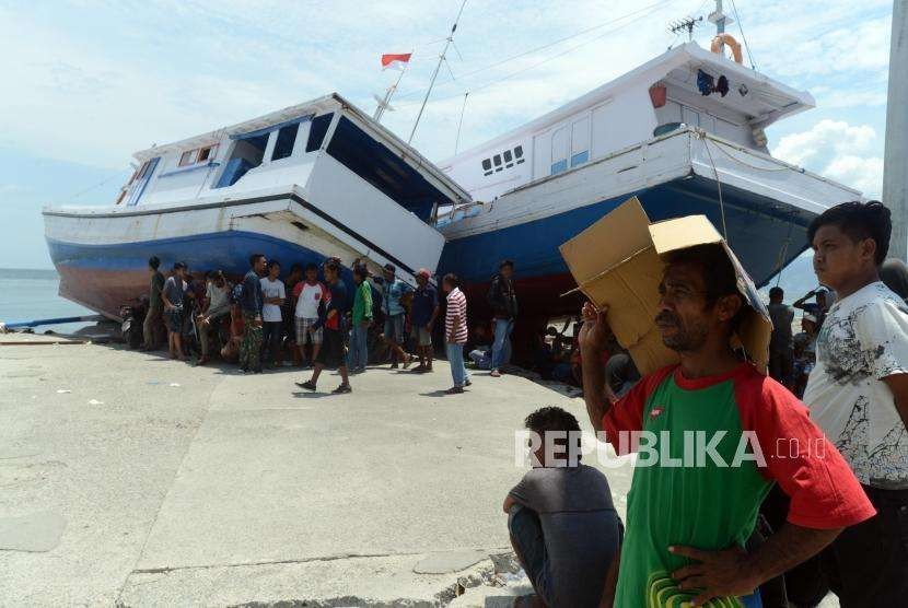 Sejumlah warga berada didekat kapal yang terdampar di Pelabuhan Wani, Palu, Sulawesi Tengah, Kamis (4/10).