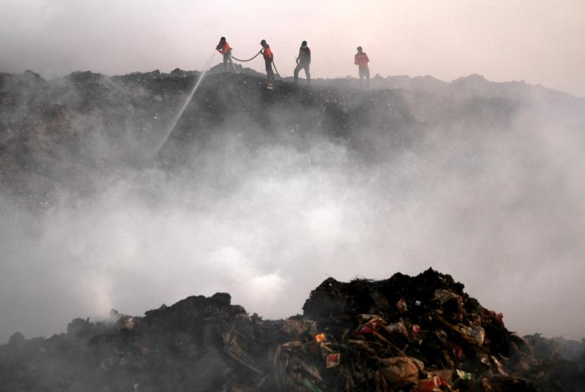 Petugas memadamkan api yang membakar sampah di Tempat Pembuangan Akhir (TPA) Antang, Makassar, Sulawesi Selatan, Selasa (17/9/2019).