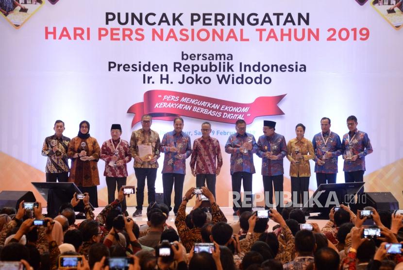 Ketua Umum Persatuan Wartawan Indonesia (PWI) Pusat Atal S.Depari (tengah) berfoto bersama para penerima penganugrahan pada acara puncak peringatan Hari Pers Nasional (HPN) 2019 di Surabaya, Jawa Timur, Sabtu (9/2).