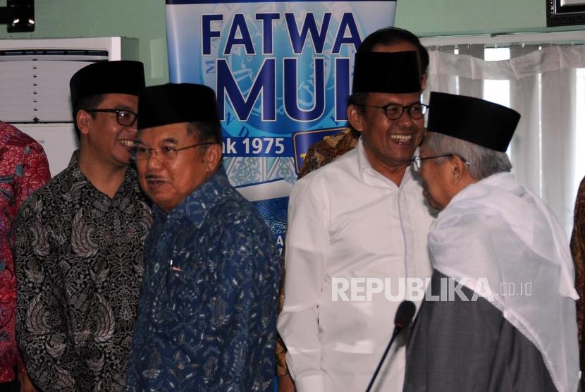 Wakil Presiden RI Jusuf Kalla (kedua kiri) dan Ketua Majelis Ulama Indonesia (MUI) KH. Ma'ruf Amin (kanan) berjalan saat akan melakukan pertemuan di Kantor MUI, Jakarta, Selasa (6/3).