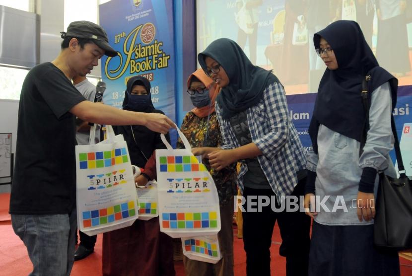 Penulis Tere Liye membagikan souvenir kepada pembaca usai kegiatan bedah buku karangannya berjudul Pergi pada acara Islamic Book Fair 2018 di Jakarta Convention Center, Jakarta, Ahad (22/4).