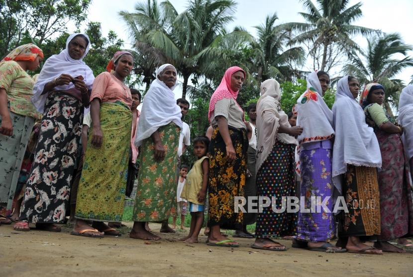Warga muslim rohingya antre mendapatkan bantuan makanan dari sejumlah lembaga zakat yang tergabung dalam Indonesian Humanitarian Alliance (IHA) di Sittwe, Myanmar.