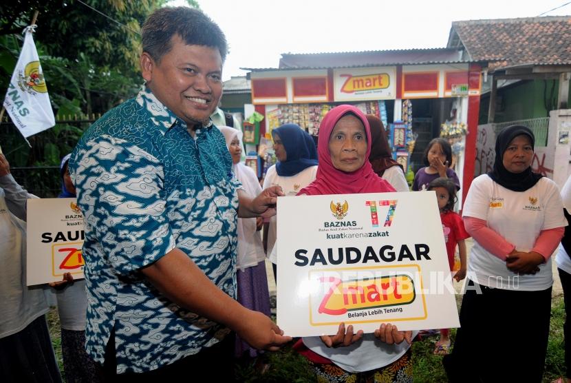 Peresmian Z-Mart. Deputi Badan Amil Zakat Nasional (Baznas) Arifin Purwakananta (kiri) memberikan bantuan kepada warga secara simbolis di Bojong Gede, Kabupaten Bogor, Jawa Barat, Rabu (17/1).
