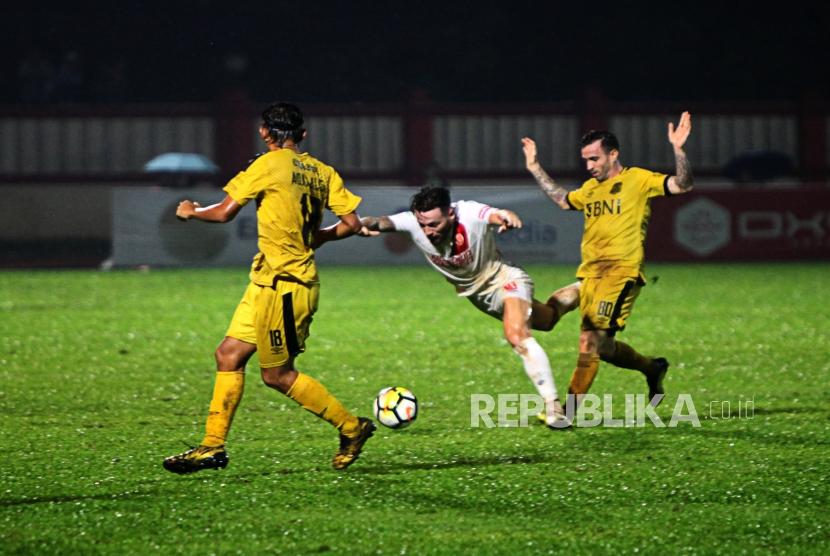 Gelandang PSM Makassar Mark Anthony Klok (tengah) dijatuhkan oleh Gelandang Bhayangkara FC Paulo Sergio (kanan) pada pertandingan Go-Jek Liga 1 2018 di Stadiun PTIK, Jakarta, Senin (3/12).