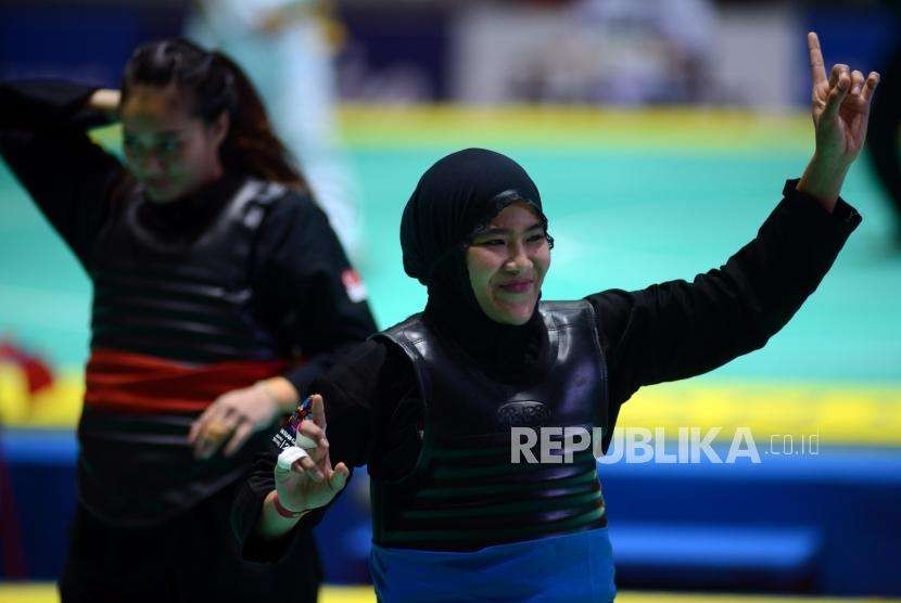 Pesilat Indonesia Pipiet Kamelia (pita biru) bertanding melawan Pesilat Singapura Nurul Suhaila Mohd Saiful pada babak perempat final cabang pencak silat putra kelas D 60-65 kg Asian Games 2018 di Padepokan Pencak Silat TMII, Jakarta, Jumat (24/8).