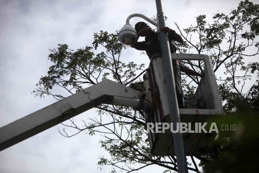 Petugas Dishub memasang CCTV ditiang persimpang Jalan Jatibaru, Tanah Abang, Jakarta, Jumat (9/2).