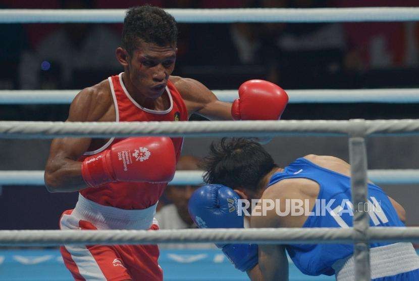 Petinju Indonesia Mario Blasius Kali (merah) bertanding melawan petinju Cina Wu Zhonglin pada babak perempat final cabang tinju kelas terbang ringan putra (49 kg) Asian Games 2018 di JIEXPO Kemayoran Jakarta, Rabu (29/8).