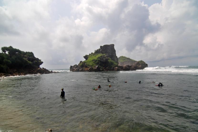 Sejumlah wisatawan bermain air di Pantai Nglambor di Tepus, Kabupaten Gunung Kidul, DI Yogyakarta, Sabtu (19/11).