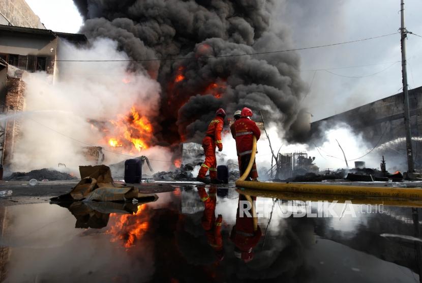 Petugas pemadam kebakaran berusaha memadamkan api yang melalap gudang di Jalan Kampung Bandan, Pademangan, Jakarta, Kamis (5/7).