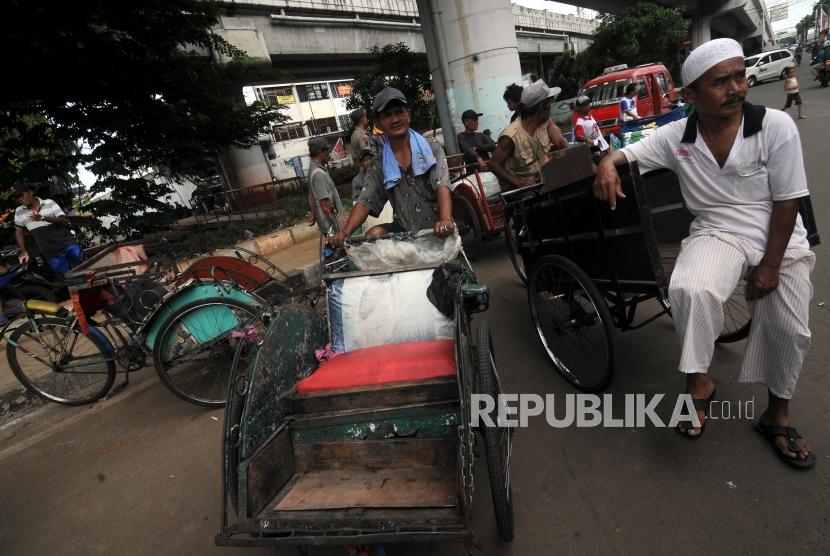 Tukang becak saat menunggu untuk didata oleh petugas di kolong flyover Bandengan Utara, Pekojan, Tambora, Jakarta Barat, Jumat (26/1).