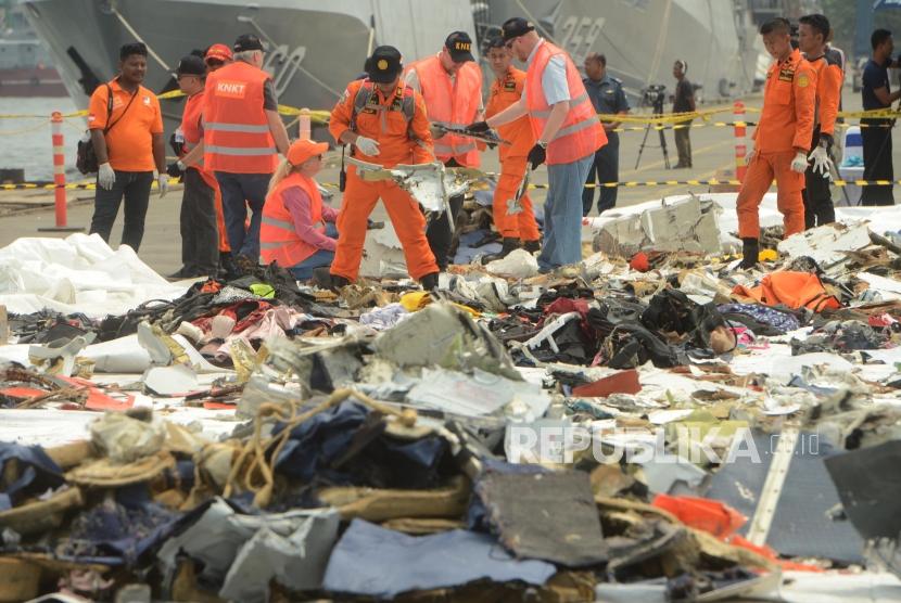 Penyelidik dari Komite Nasional Keselamatan dan Transportasi (KNKT) Indonesia dan Dewan Keselamatan Transportasi Nasional (NTSB) Amerika serikat saat memeriksa puing-puing pesawat Lion Air JT 610 di Terminal JICT 2, Tanjung Priok, Jakarta, Kamis (1/11).