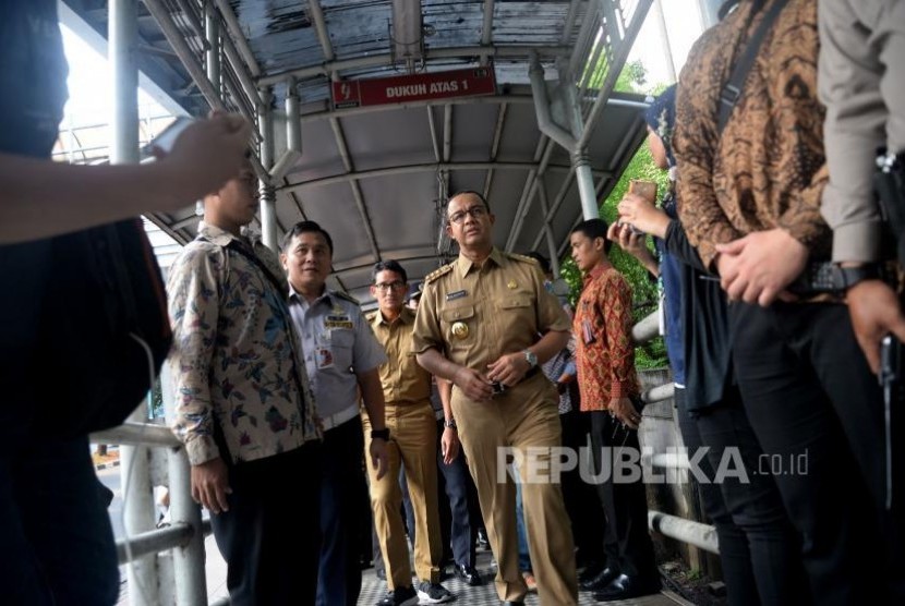 Gubernur DKI Jakarta Anies Baswedan dan Wakil Gubernur Sandiaga Uno berjalan ketika hendak menaiki bus Transjakarta di Halte Dukuh Atas, Jakarta (Ilustrasi)