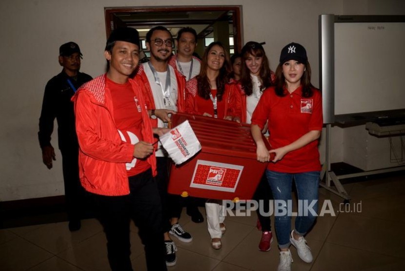 Ketua Partai Solidaritas Indonesia (PSI) Grace Natalie (kanan) bersama pengurus PSI membawa kontainer berisi berkas dan syarat-syarat pendaftaran ketika mendaftarkan partainya di KPU Pusat, Jakarta, Selasa (10/10).  