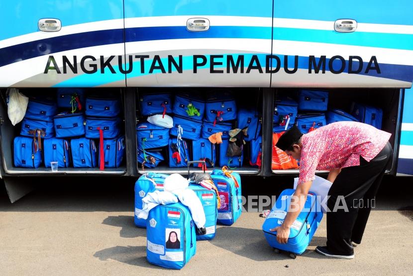 Petugas memasukan tas calon jamaah haji ke dalam bagasi bus sebelum berangkat ke Bandara Soekarno Hatta di Asrama Haji Pondok Gede, Jakarta, Rabu (18/7).