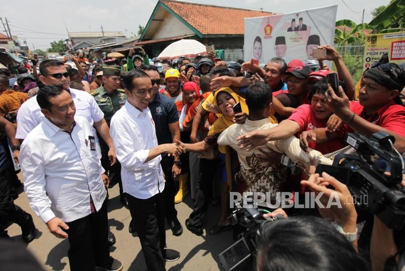 Presiden Joko Widodo bersama Bupati Cilacap Tatto Suwarto Pamuji (kiri) menyapa warga saat meninjau barang kebutuhan pokok di Pasar Pelemgading, Cilacap, Jawa Tengah, Senin (25/2). Ilustrasi.