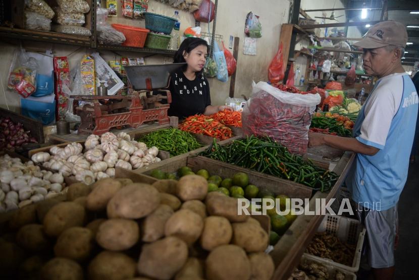 Pedagang sayuran melayani pembeli di Pasar Rumput, Jakarta, Senin (1/7).