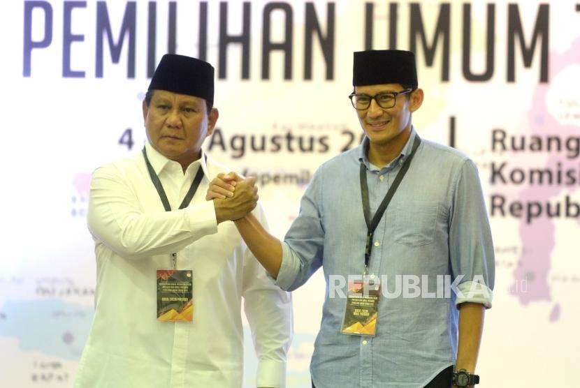 Vice presidential candidate of the opposition camp Sandiaga Uno (right) and presidential candidate Prabowo Subianto hold hand after registering themselves as participant of presidential election 2019 to General Election Commission, Jakarta, on Friday (Aug 10). Sandiaga wears soft blue shirt to express hope on a peaceful election.