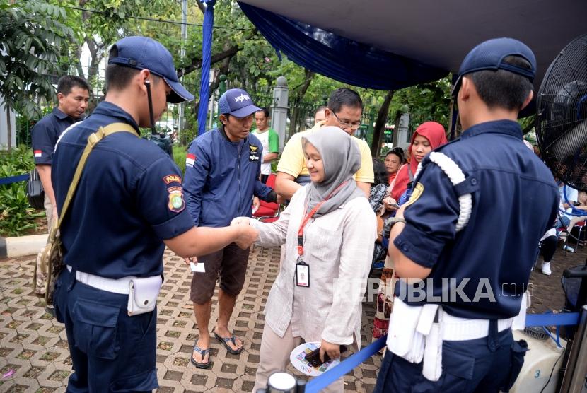 Penukaran Pecahan Rupiah. Warga antre menukarkan uang Rupiah di mobil kas keliling Bank Syariah Mandiri di Lapangan IRTI Monas, Jakarta, Rabu (23/5).