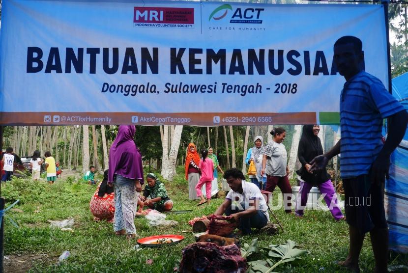 Ibu-ibu dan bapak-bapak pengungsi bergotong royong memotong-motong daging sapi dan memasak di dapur umum Posko Kemanusiaan ACT, di desa Lompio, Kabupaten Sirenja, Donggala Sulawesi Tengah (Ilustrasi)