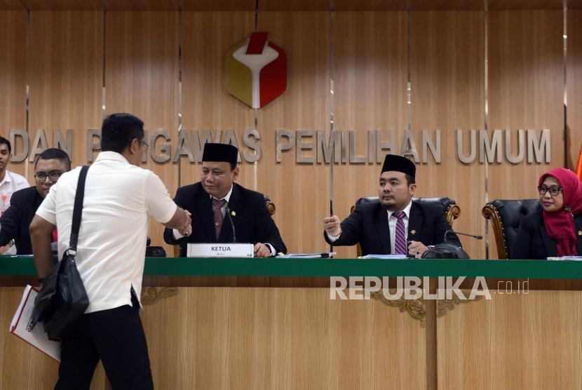 Ketua Bawaslu Abhan bersalaman dengan perwakilan dari BPN Prabowo-Sandi usai sidang pembacaan putusan pendahuluan atas dugaan kecurangan pemilu terstruktur, sistematis dan masif di kantor Bawaslu, Jakarta, Senin (20/5).