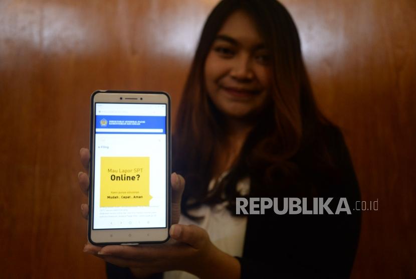 Seorang wajib pajak menunjukan informasi mengenai pengisian SPT secara online di Jakarta, Jumat (9/3).