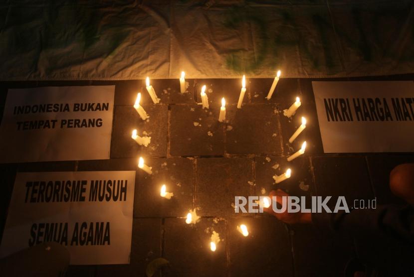 Seorang suporter menyalakan lilin saat aksi solidaritas terkait aksi tragedi teror bom di Surabaya dan Siduarjo di Taman Suropati, Jakarta, Senin (14/5).